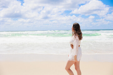 Fototapeta na wymiar 海辺を歩く白いドレスの白人の少女の横顔