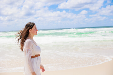 海辺を歩く白いドレスの白人の少女の横顔