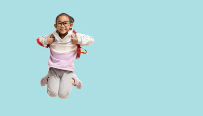 School girl, Happy smiling Asian student school kid jumping for joy with carry a bag, Full body portrait isolated on pastel plain light blue background