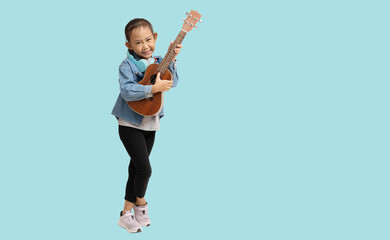 School girl, Happy smiling Asian student school kid hand holding guitar ukulele, Full body portrait isolated on pastel plain light blue background