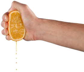 Hand holds orange fruit and squeezes out juice squeeze
