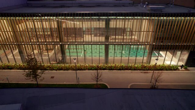 Aerial view of Recreation complex, indoor pool with swimming lanes looking into the building at night