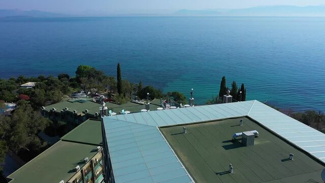 Tracking shot view Hotel Mythos Palace, Corfu, Greece on the sea and the coastline.