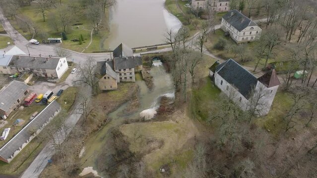 Aerial establishing view of high water in springtime, flood, Durbe river (Latvia), Cirava city, brown and muddy water, sunny day, wide drone birdseye shot moving forward