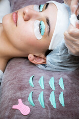The master removes the composition for lamination from the client's eyelashes with a cotton swab....