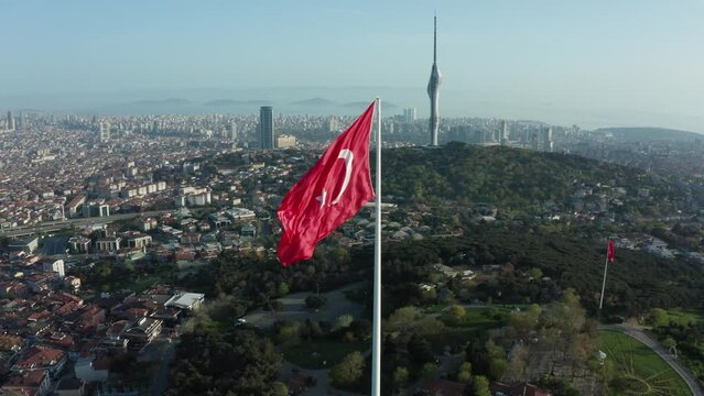 Aerial view of the glorious Turkish flag waving from the hill, which has the most beautiful view of Istanbul, which sees the bridge connecting Asia and Europe.