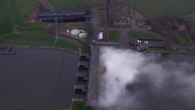Reveal shot of Woudagemaal Steam Pumping Station under steam, Aerial 4k