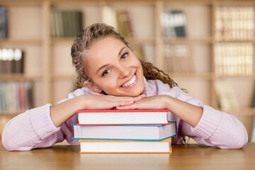 Beautiful young woman with a lot of books