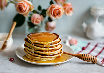 delicious pancakes with roses poured honey and cherry on the table