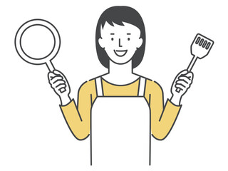 フライパンとフライパン返しを両手に持つ主婦