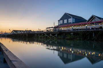 Fototapeta premium restaurant at the pier showing reflection on the calm water at sunset
