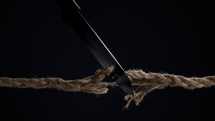 The stretched cord is cut with a knife on a dark background. The rope is about to break. The...