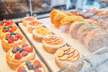 fresh pastries with berries. A variety of fresh pastries in the bakery window. almond croissant is fresh and hot in a cafe next to other types of pastries. The interior of an Italian restaurant.