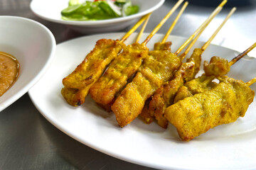 Grilled pork satay on white plate