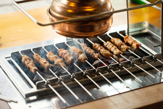 Grilled lamb skewers over charcoal