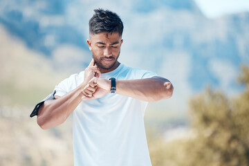 Health, smartwatch and athlete training heart rate for outdoor sports, marathon or cardio strength with mountain exercise. Fitness, watch and young man or runner on a hike workout for wellness