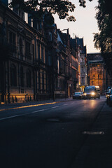 Fototapeta na wymiar Trier during sunset. Early evening. Lone van driving through a main street in the city.