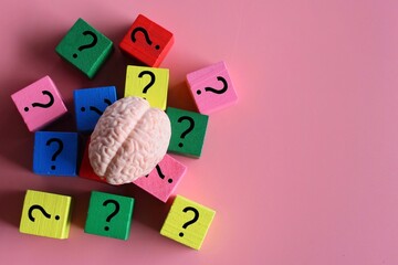 Top view image of brain and wooden cubes with question mark icon. Copy space for text. Confusion, doubt, brainstorming concept