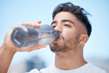 Man, fitness and drinking water in city for sustainability after running exercise, workout or...