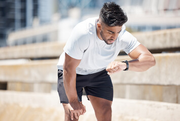 Man, fitness and checking watch after running exercise, cardio workout or training in city. Fit,...