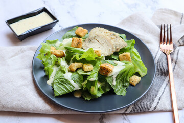 Caesar salad with chicken - Healthy food served in black dish