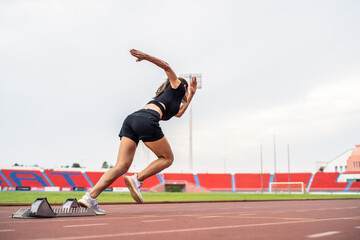 Asian young sportswoman sprint on a running track outdoors on stadium
