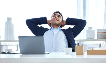 Naklejka premium Relax, business and man with a smile, laptop and good deal in an office, calm and stretching. Male person, consultant and agent in a workplace, rest and peace with sales, connection and finished task
