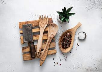 Olive tree tray with cooking utensils and meat cleaver on kitchen background. Top view.