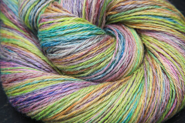 Closeup detail of a colourful skein of organic natural handspun and handdyed merino sheep wool,...