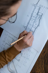 Architect drawing blueprint sketching design of house, making architectural construction building.