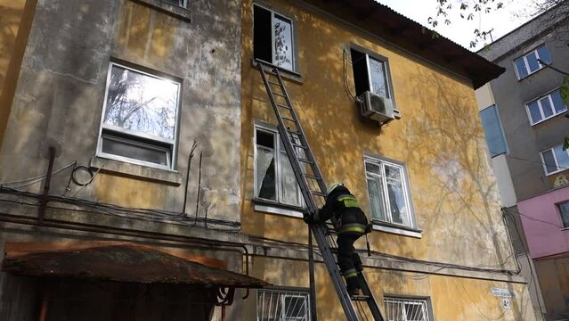 View of a brave firefighter in a protective uniform. Rescuer in protective gear. Firefighters put out a fire in a residential building. DNIPRO, UKRAINE  April 30, 2021
