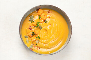 Pumpkin traditional soup with creamy silky texture on a white background.