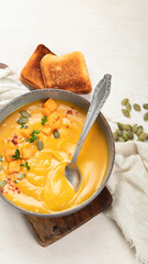Pumpkin traditional soup with creamy silky texture on a white background.