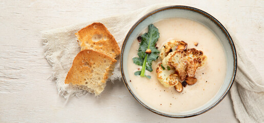 Roasted cauliflower soup served with grilled bread.