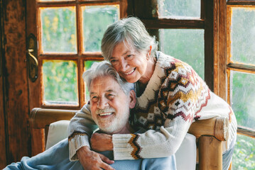 Senior couple at home sitting and relaxing together hugging and looking. Mature love and retirement...