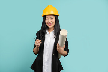Happy smiling business woman developer holding blueprints on green background