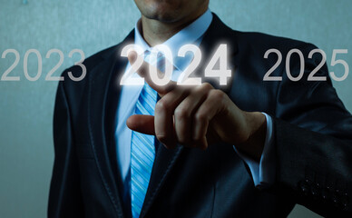 A man touching on virtual screen 2024. Business new year concept, welcome to year 2024 concept.