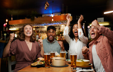 Young multiracial group of friends in casual clothing shouting and celebrating at restaurant