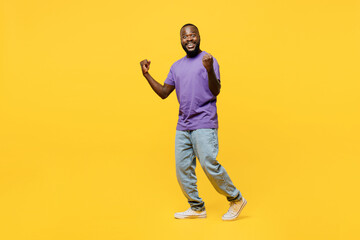 Full body sideways young man of African American ethnicity wears casual clothes purple t-shirt walk...