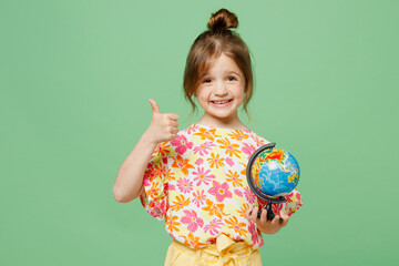 Little cute child kid girl 6-7 years old wear casual clothes have fun hold in hands globe Earth map show thumb up isolated on plain pastel green background. Mother's Day love family lifestyle concept.