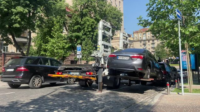  Loading a car on a tow truck for parking violation. 