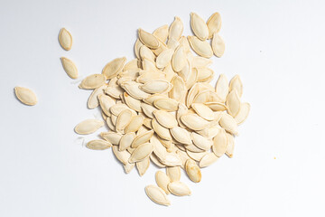 Pile of raw pumpkin seeds on white background, top view.