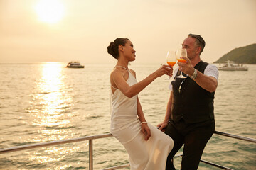 Fototapeta premium couple drinking orange juice in luxury yacht