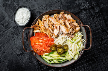 Shawarma Doner kebab on a plate with french fries and salad. Black background. Top view