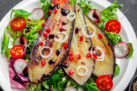 eggplant salad tomato, red pepper, green leaves fried vegetable snack on the table copy space food background rustic top view