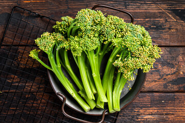 Fresh Raw Organic Broccolini cabbage in a steel tray. Wooden background. Top view
