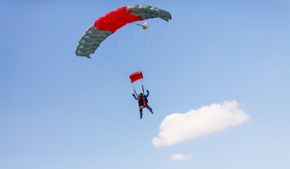 Skydiver with a little canopy of a parachute on the background a blue sky, close-up. Skydiver under parachute