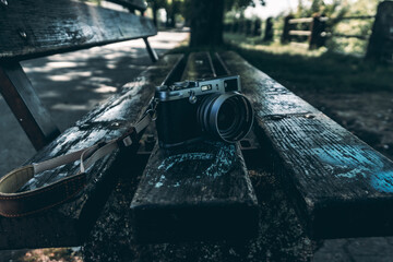 Close up of digital camera on park bench. Retro styled camera. Editorial style.