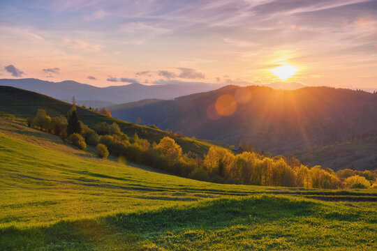natural beauty of the rural landscape. grassy rolling hills in evening light. mountain ridge in the distance © Pellinni