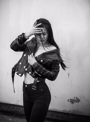 Grunge style, Beautiful sexy young woman with a dark long hair in leather jacket. Style of 90s